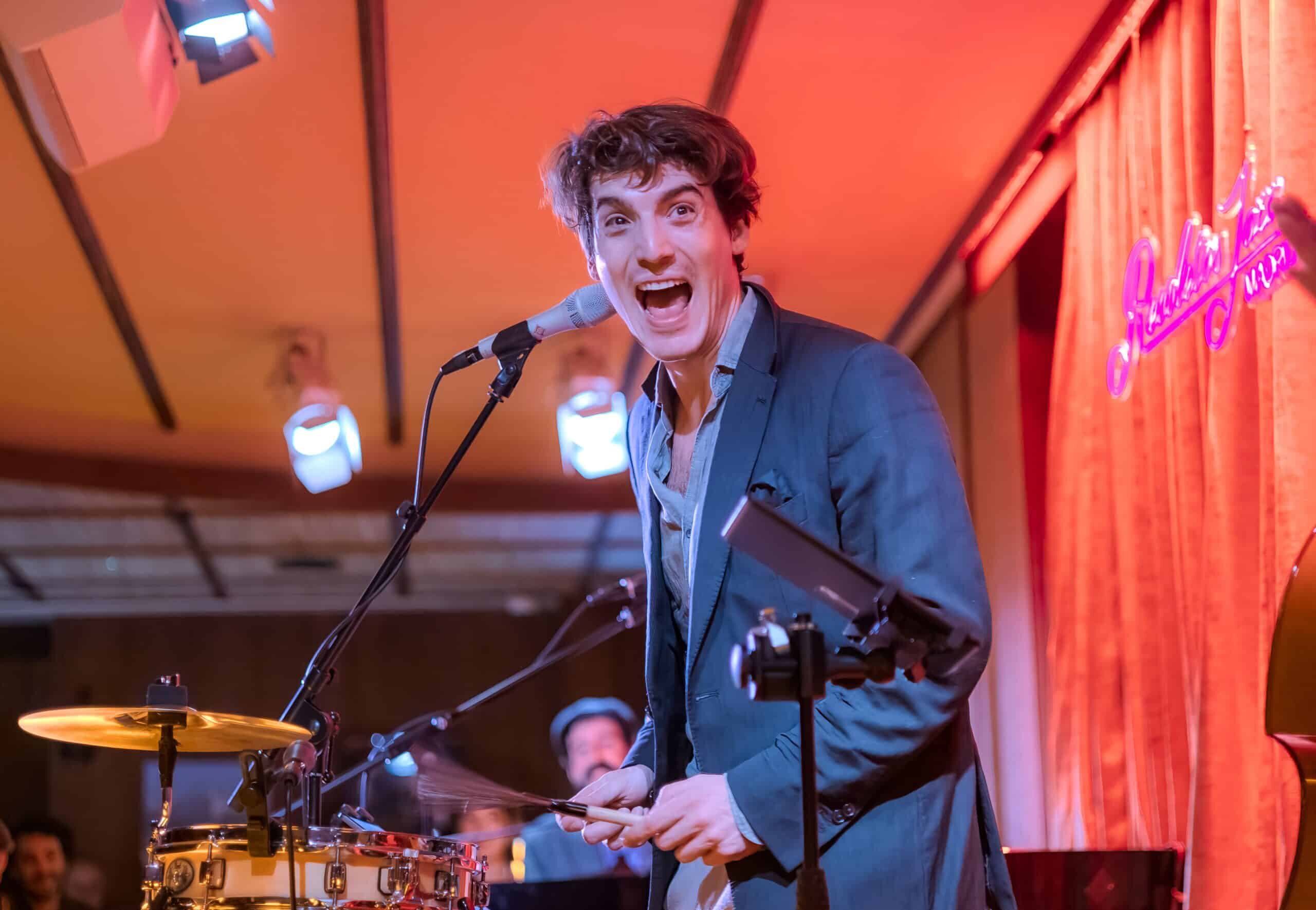 Musician performing live on stage with vibrant energy and audience interaction.