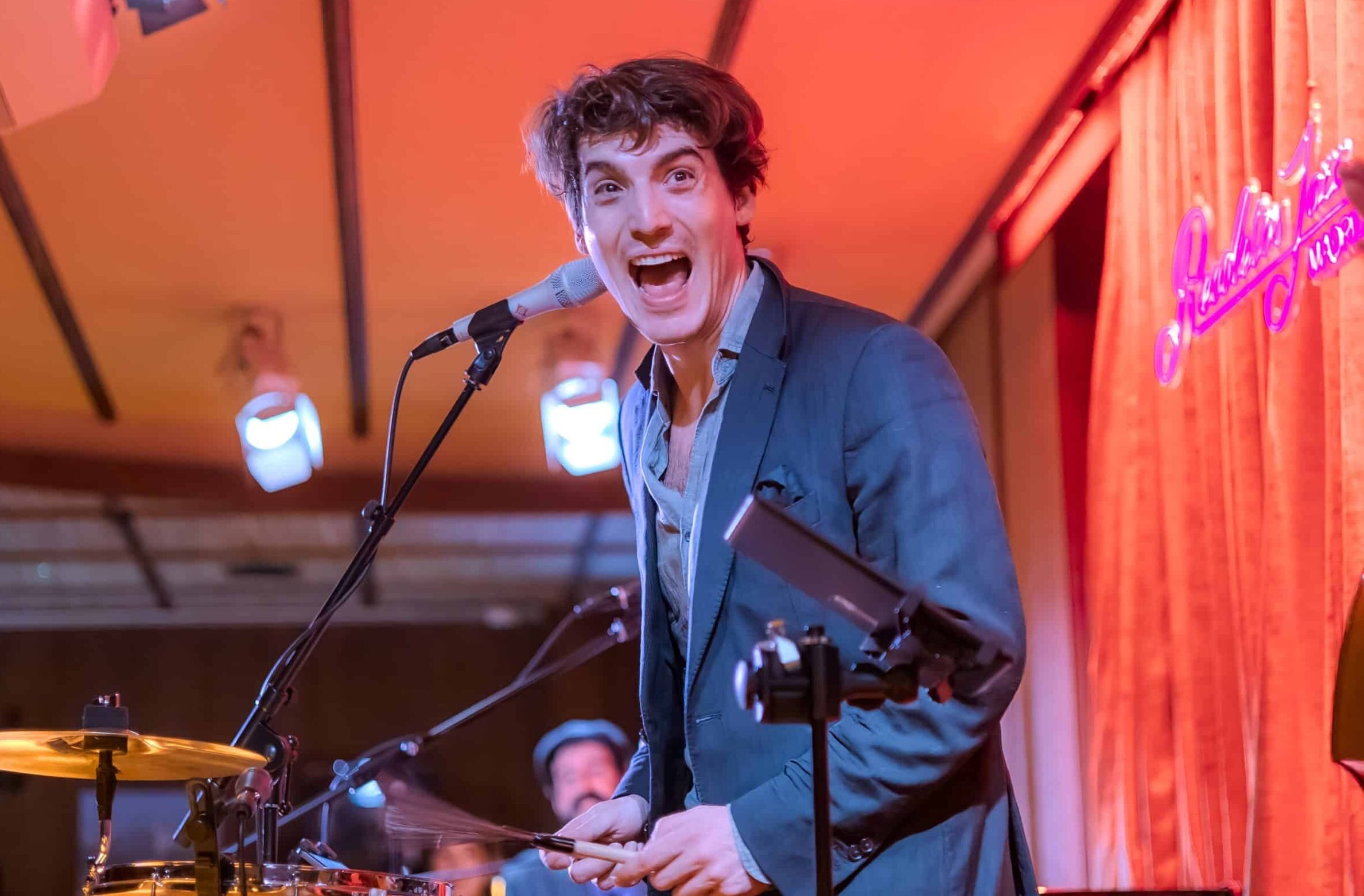 Musician performing live on stage with vibrant energy and audience interaction.